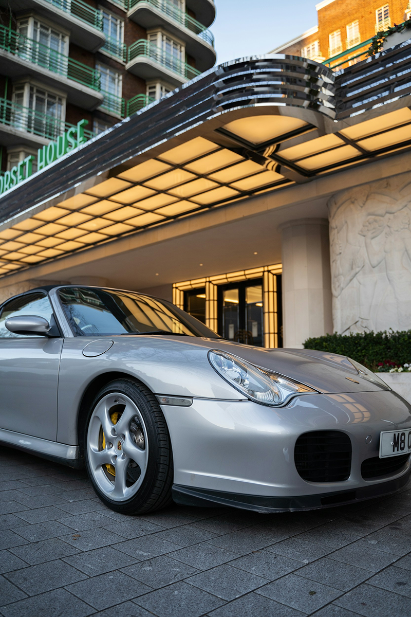 Auto sportiva argento parcheggiata davanti a un hotel