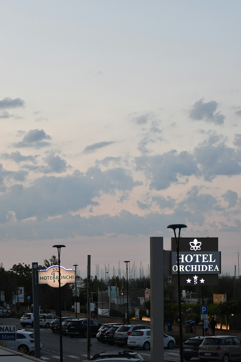 Insegne di hotel all'ingresso di un parcheggio al tramonto